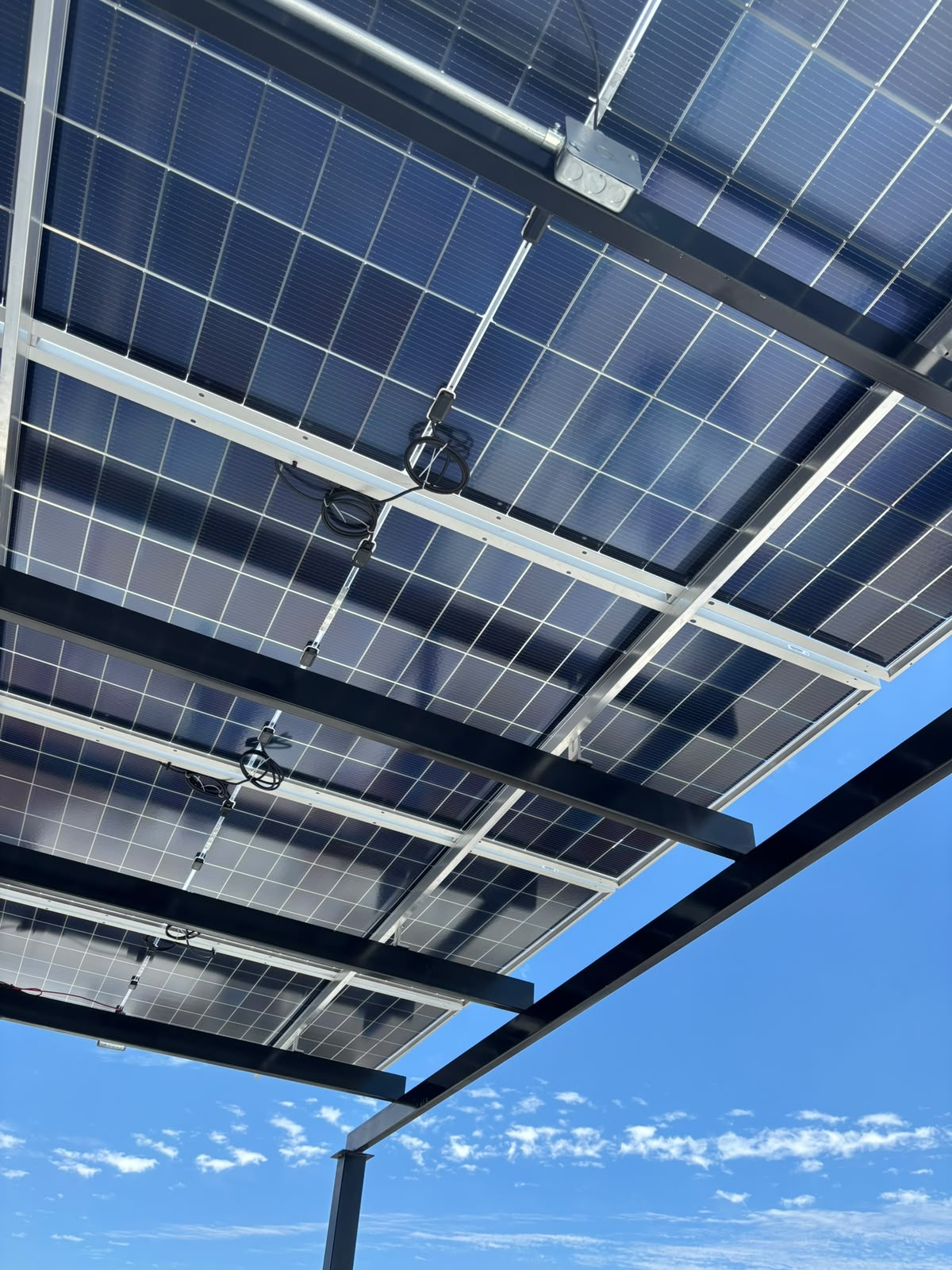 Detalle de cableado y microinversores bajo paneles solares